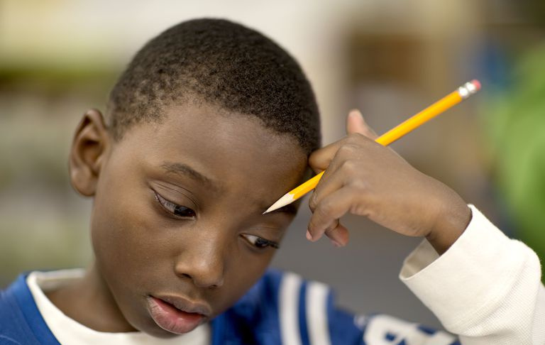 Il ragazzo di quarta elementare lavora su un problema di matematica.