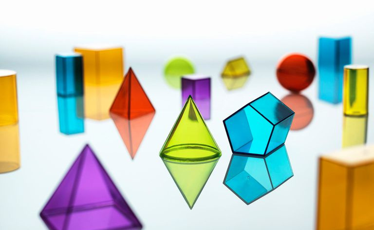 Grupo de várias formas geométricas multicoloridas descansando em um espelho