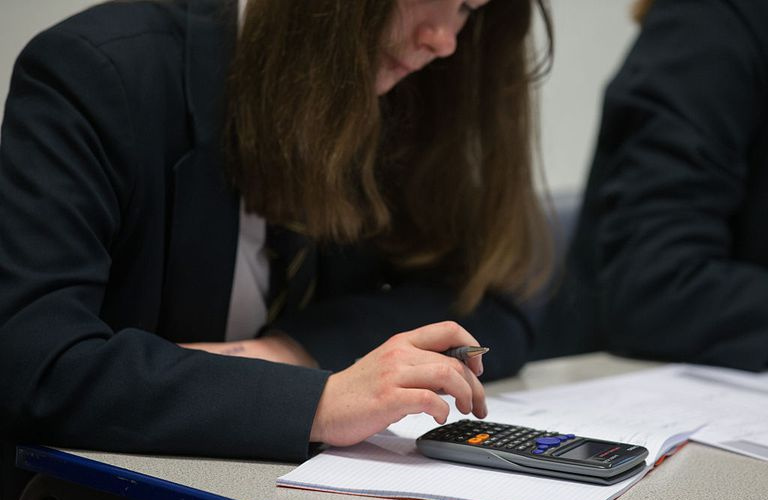 Mulher usando uma calculadora durante um teste.