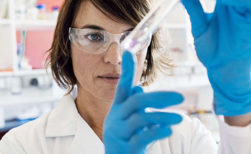 Ernsthafter Chemiker, der Chemikalie im Reagenzglas analysiert