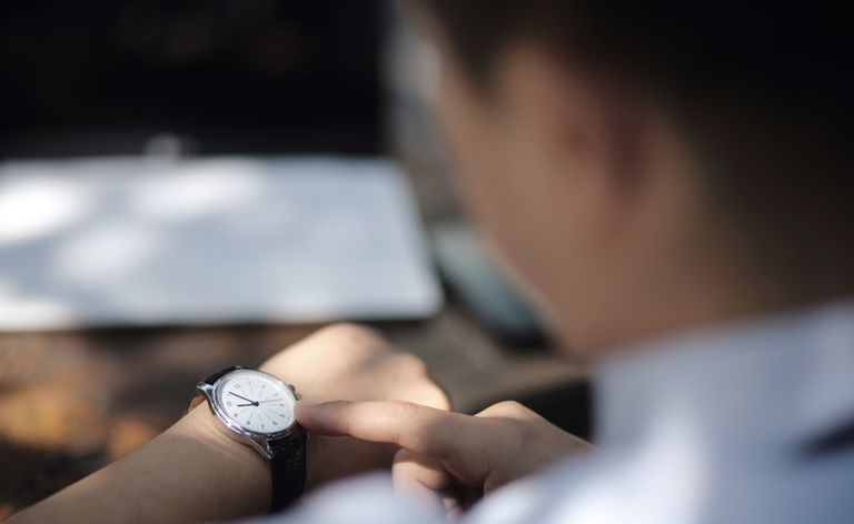 Empresario comprobando la hora en su reloj