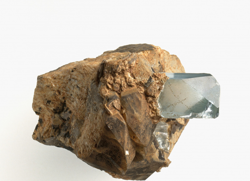 Mėlynas topazo kristalas pegmatite baltame fone.