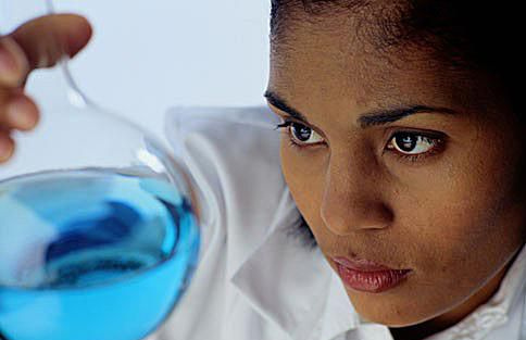 Chemiker, der eine Flasche Flüssigkeit untersucht.