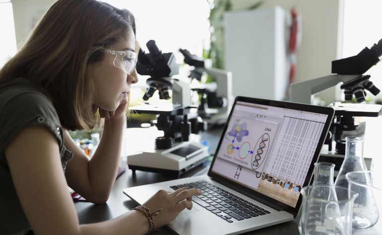 Estudante universitário usando laptop no laboratório de ciências.