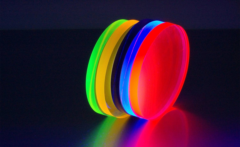Discos de plástico brilhando sob luz negra.