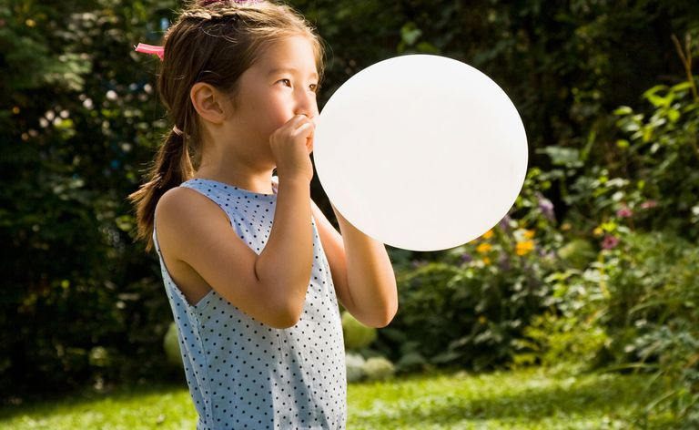 Młoda dziewczyna nadmuchująca balon