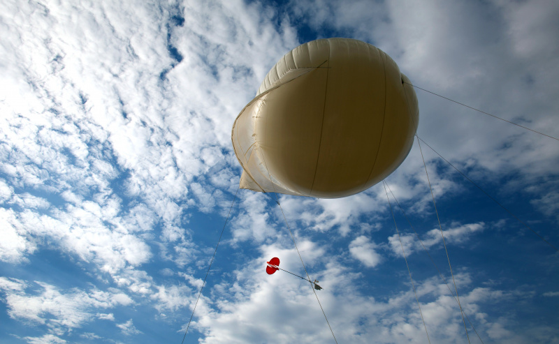 Um balão meteorológico amarrado para testar a qualidade do ar nacional sobe lentamente para o céu