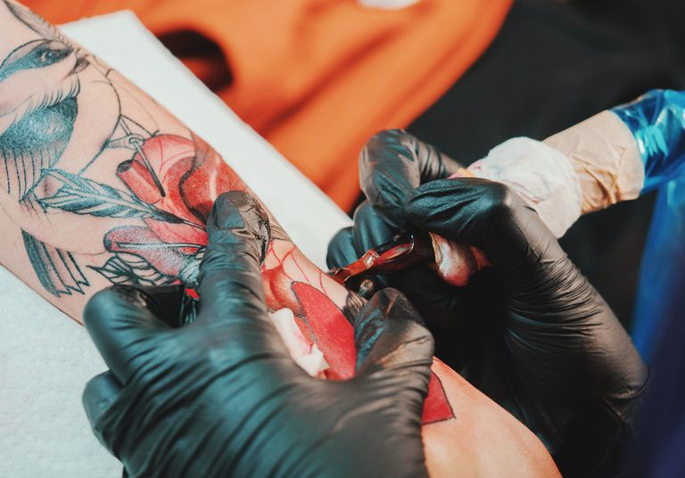 Artistes encrant un tatouage rouge