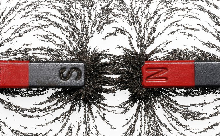 Zwischen zwei Stabmagneten gestreute Eisenspäne