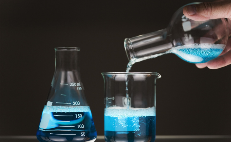 Versare liquido blu tra i flaconi