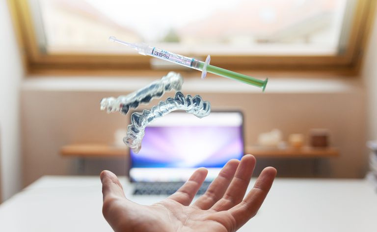 Hand ausgestreckt in Richtung Home-Office-Bereich mit wissenschaftlichen Objekten, die auf dem Bildschirm schweben.