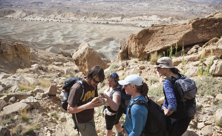 Des étudiants en géologie interprètent une roche trouvée sous le bord de North Caineville Mesa, Utah.