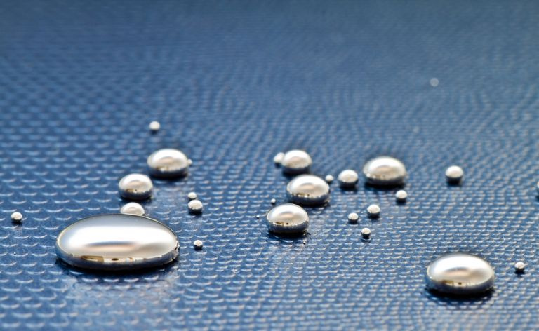 Gotas de mercúrio em uma superfície azul textural
