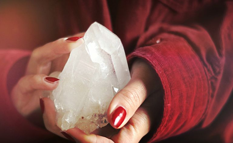 Mains féminines tenant un grand cristal se bouchent.