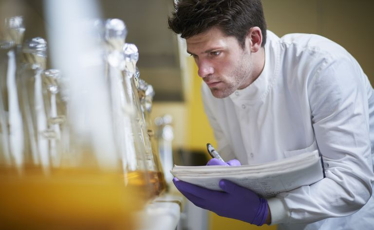 Muž vedecký študent pri pohľade na banky a robiť si poznámky