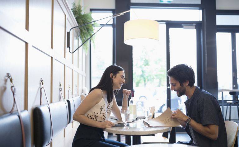 Mężczyzna i kobieta siedzą naprzeciwko siebie w restauracji.