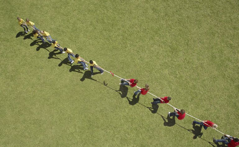 Due squadre, una che indossa magliette rosse e una che indossa magliette gialle, competono in un gioco di tiro alla fune.