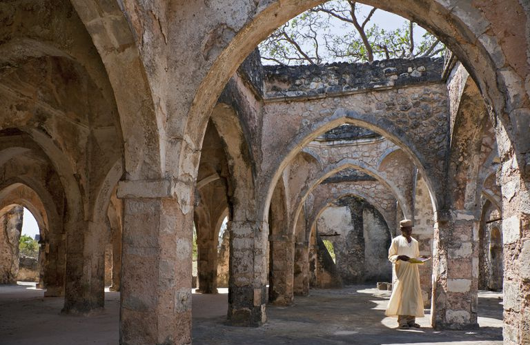 Homme debout dans les ruines de la mosquée de Kilwa Kisiwa.