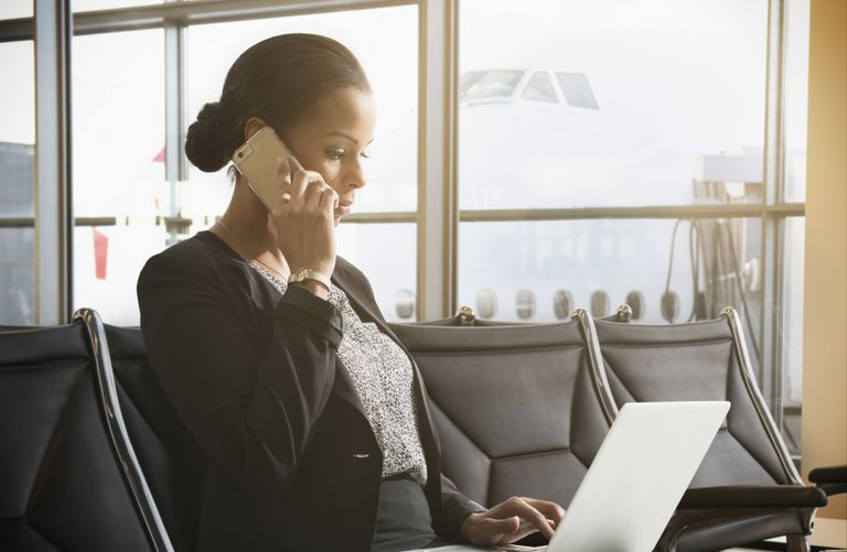Imprenditrice afro-americana che lavora al computer portatile in aeroporto