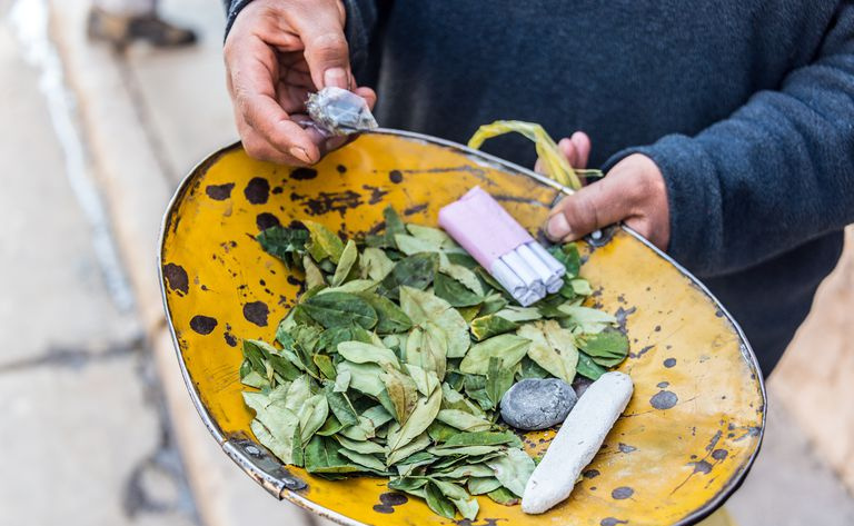 Folhas de coca e cigarros no prato