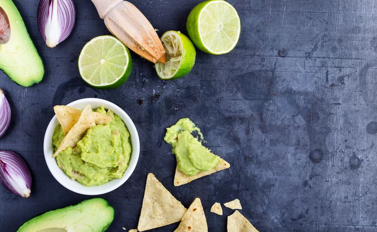 Domowy dip guacamole z awokado ze świeżymi składnikami na szarym tle z miejsca kopiowania