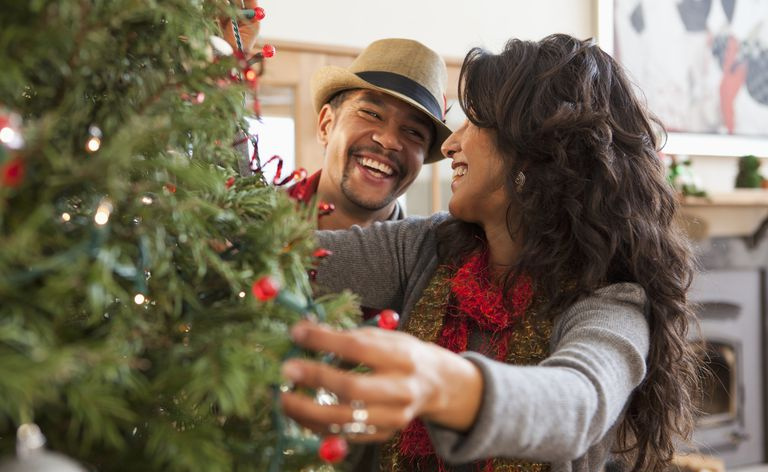 Paare, die Weihnachtsbaum schmücken