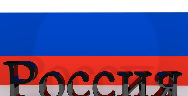 Cyrylica wykonana z ciemnego metalu oznaczająca Rosję przed rosyjską flagą