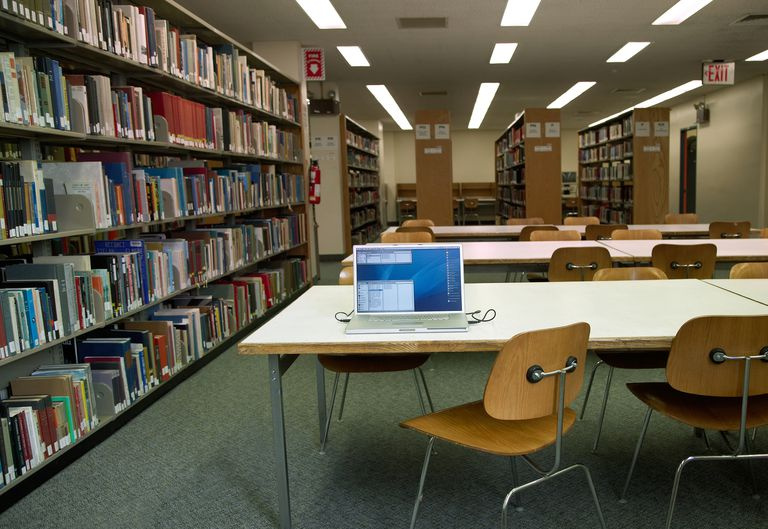 Computador portátil aberto na mesa da biblioteca