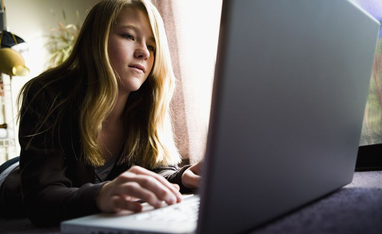ラップトップ コンピューターを持つ 10 代の少女