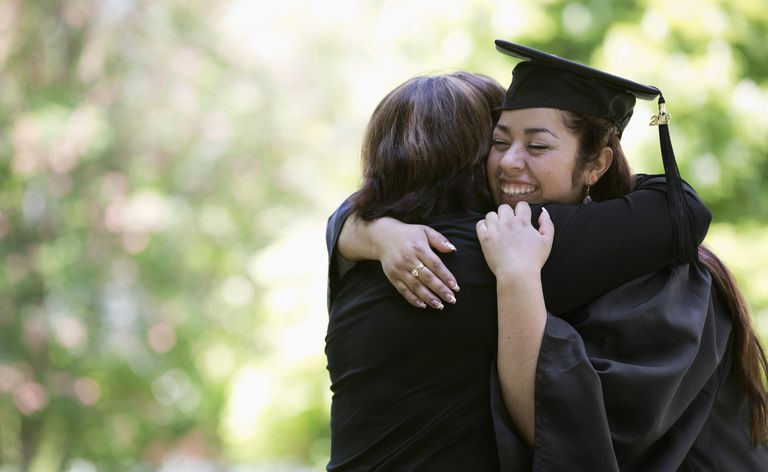 Madre abrazando a hija graduada universitaria