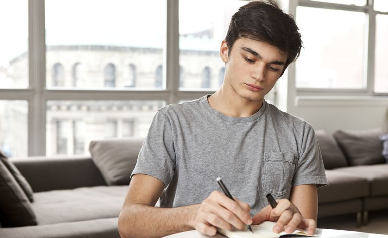adolescent à la maison écrivant des notes