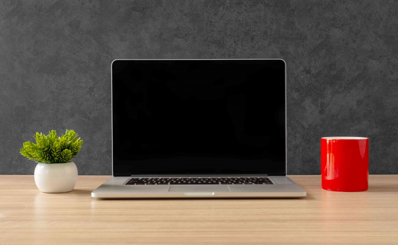Laptop y taza de café roja en el escritorio de la oficina