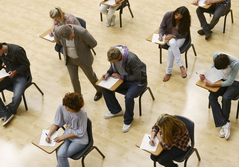 Profesor chodzący przez studentów zdających test w klasie