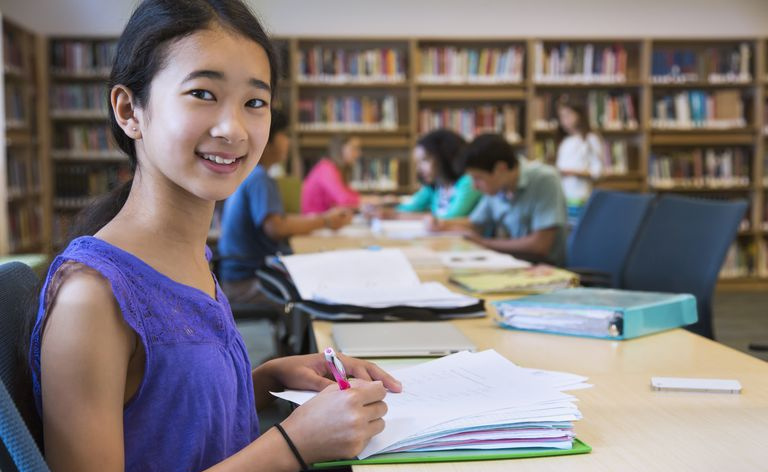 Student tar notater i biblioteket