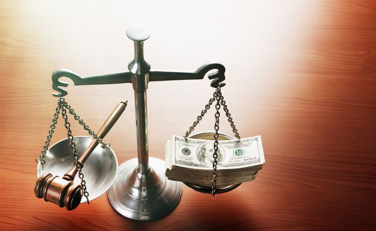 Escalas de justiça com pilhas de dólares