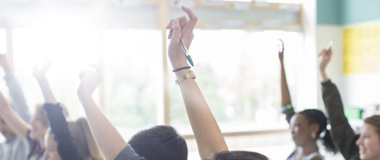 Mãos levantadas na sala de aula