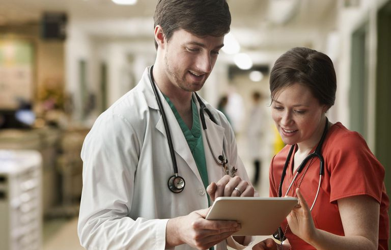 Medico e infermiere caucasici che utilizzano computer tablet