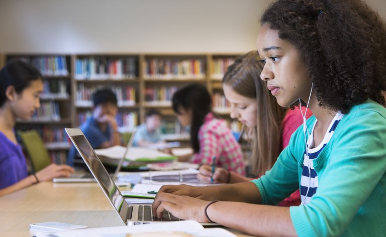 Student korzystający z laptopa w bibliotece