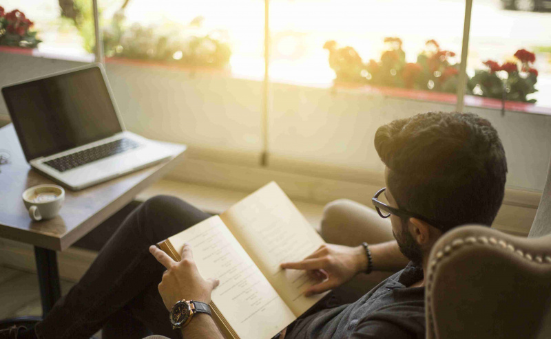 Giovane che legge un libro in un caffè