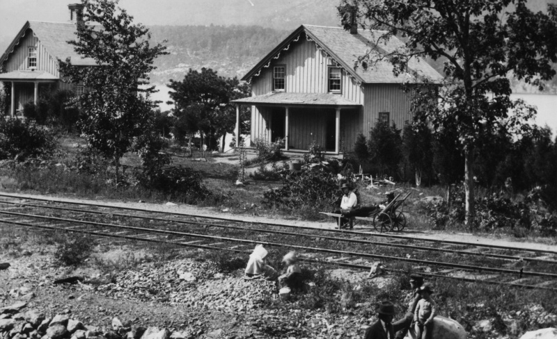 foto histórica en blanco y negro de casas junto a las vías del tren