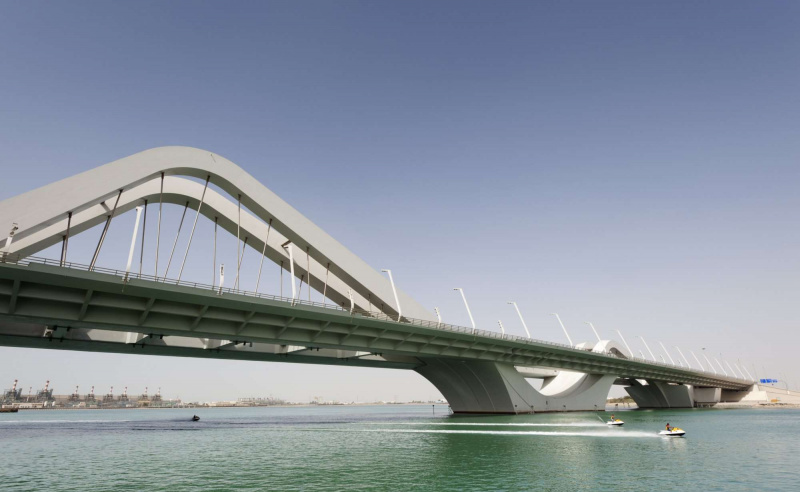 Snelwegbrug met vrijdragende wegdekken opgehangen aan symmetrische stalen bogen
