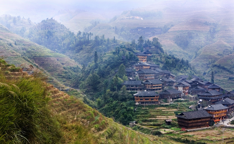 Wioska z tradycyjnymi domami przy polach ryżowych w Longji, prowincja Guangxi, Chiny