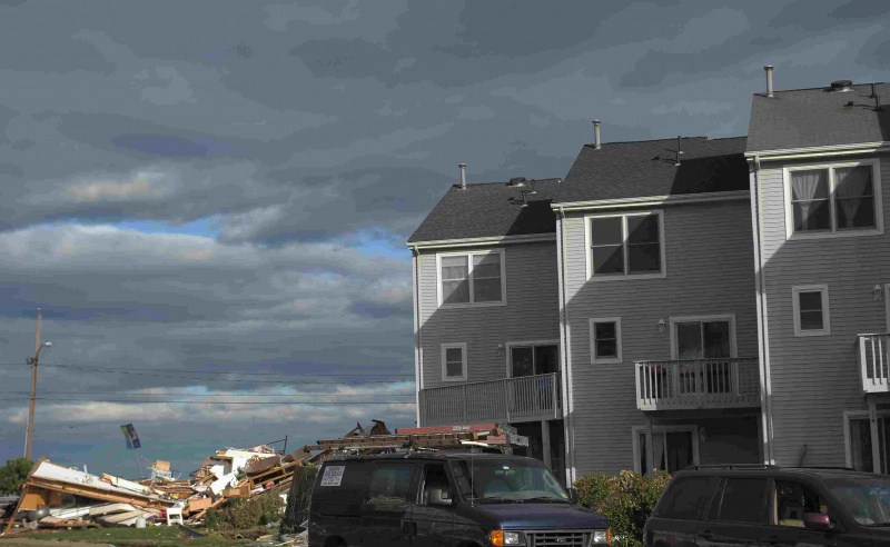 Kamienice stoją w pobliżu zawalonej konstrukcji w następstwie Superstorm Sandy 2 listopada 2012 r. W Union Beach w New Jersey