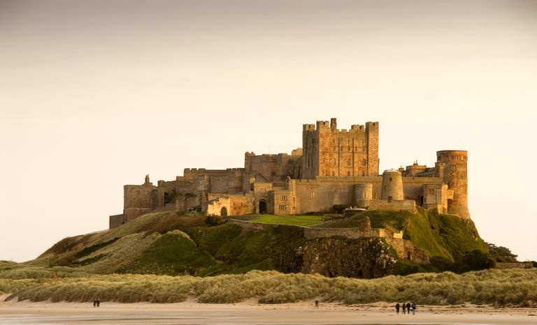 Bamburgh Castle tagsüber mit Passanten am Strand