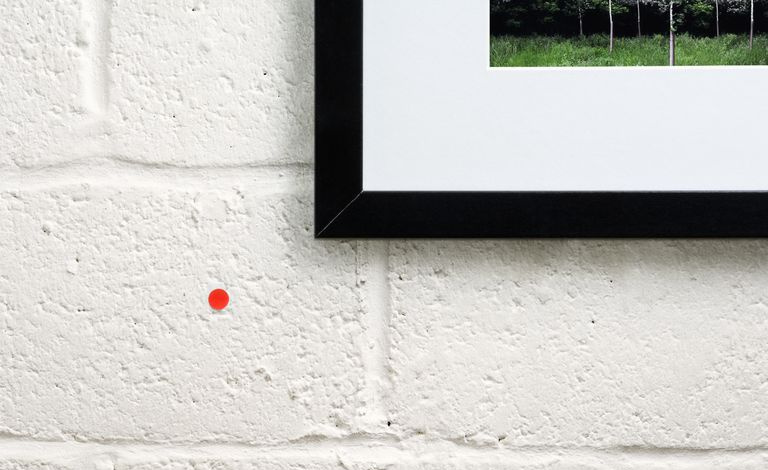 Una pequeña etiqueta naranja al lado de una obra de arte indica que se ha comprado